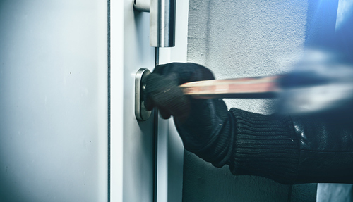 Einbrecher versucht eine Haustür aufzuberechen
